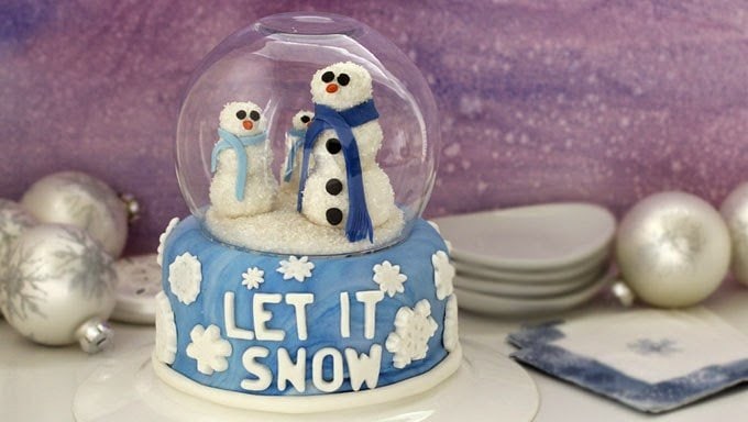 snow globe cake with snowmen inside a glass bubble