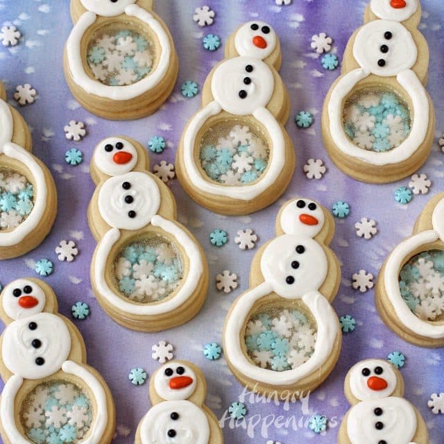 Snowman cookies with candy glass and snowflakes in their belly period