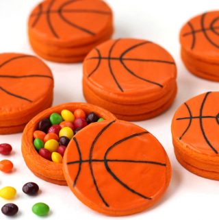 Basketball pinata cookies filled with Skittles are decorated with orange candy melts.