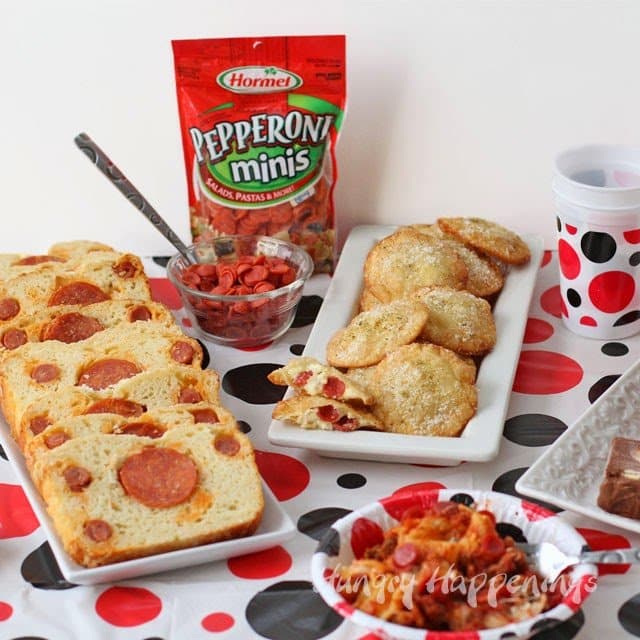 table decorated with a polka dot tablecloth, pepperoni bread, fried pepperoni won tons, and mini pepperoni. 
