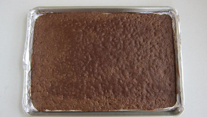 spread brownie mix into thin layer, bake, cut using football cookie cutter, fill with candy, decorate with frotsing