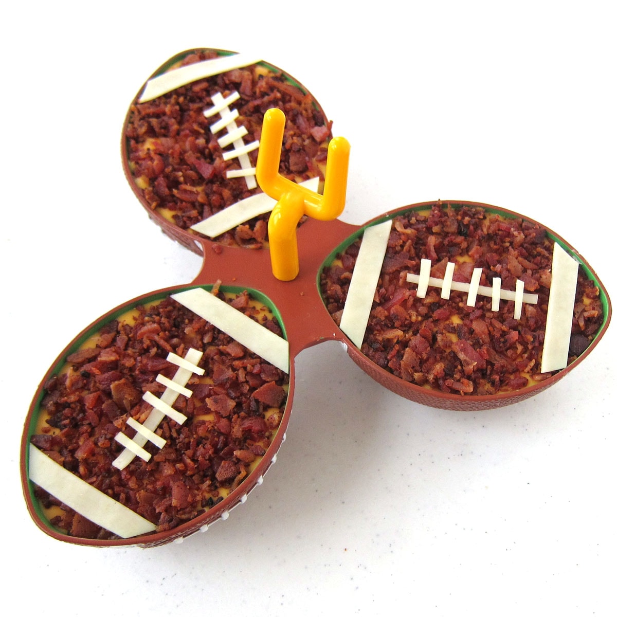 football party appetizer beer bacon cheese dip in football bowls. 