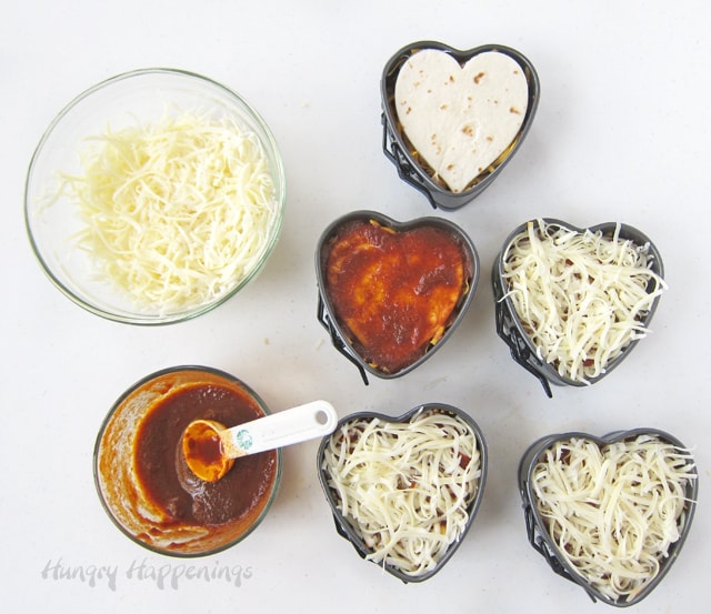 top heart-shaped chicken enchildas with sauce and Monterey Jack cheese.