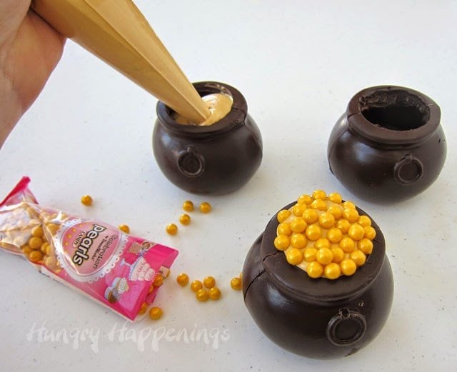 filling chocolate pots with caramel mousse and gold candy pearls