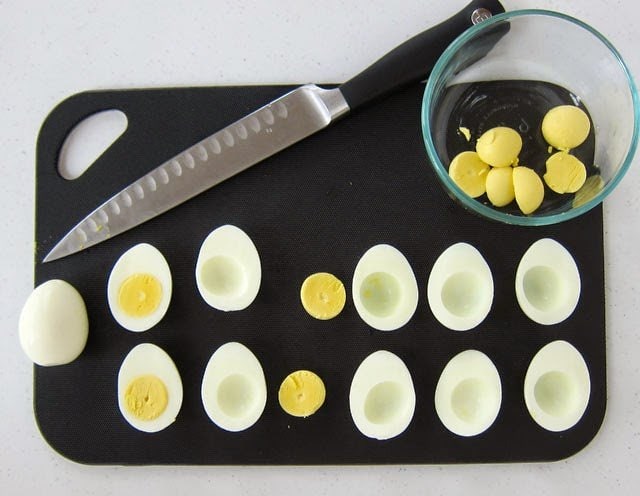 cut hard-boiled eggs in half and remove yolks