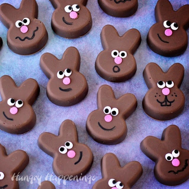 chocolate peanut butter fudge Easter bunnies with smiley faces arranged on a purple paper background.
