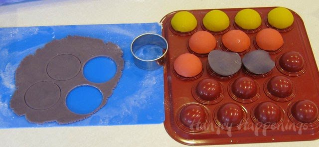 cut circles out of purple cookie dough the set the circles over the cake ball pan and form them to the pan