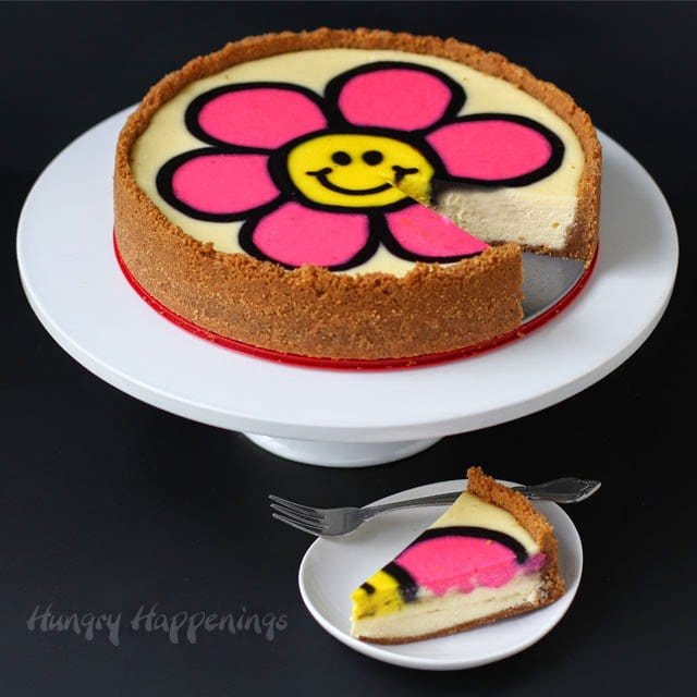 Decorated Cheesecake with a bright pink smiley face daisy on top