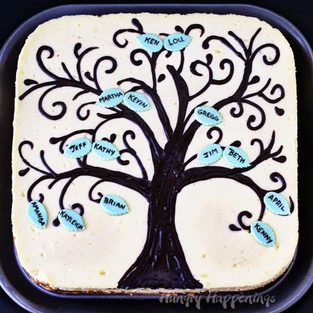 cheesecake topped with a family tree with names printed on the leaves.