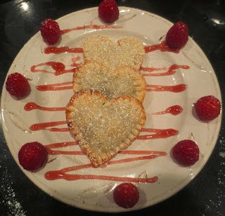 chocolate pastry hearts served with raspberry sauce and raspberries. 