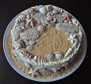 beach-themed cake with edible stones and seashells. 