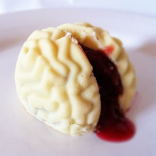white chocolate cake ball brain with oozing raspberry sauce blood. 