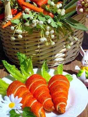 crescent roll carrots served on a white plate set in front of a pretty basket. 
