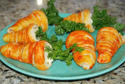 carrot crescent rolls served on a green plate. 