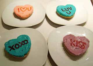 small conversation heart cheesecakes on white dessert plates. 