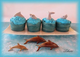 ocean cupcakes topped with dolphins. 