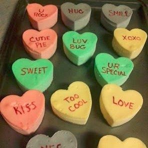 conversation heart cheesecakes on a baking tray. 