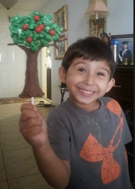 smiling boy holding a popcorn tree.