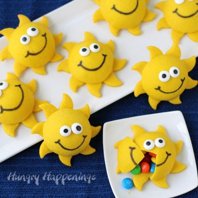 3-D sunshine cookies filled with candy set on a white plate on a blue tablecloth