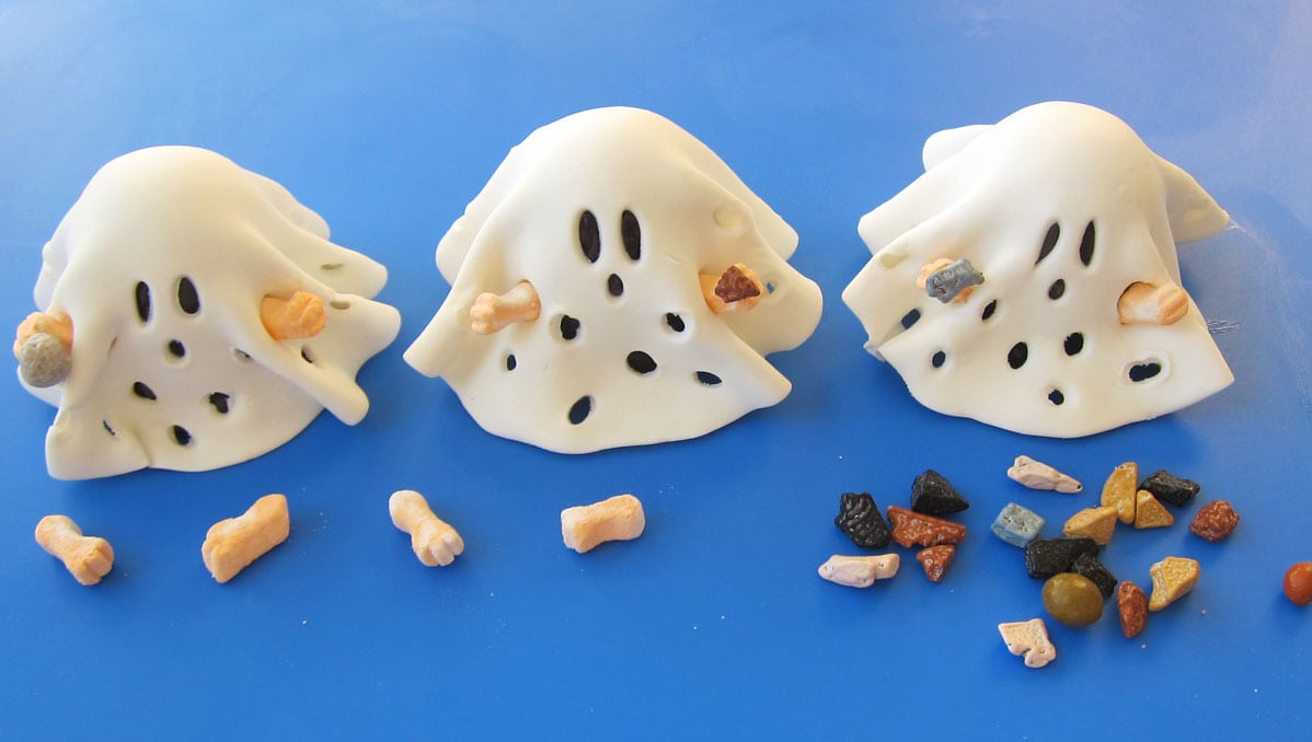 decorating Halloween brownie ghosts with Charlie Brown Ghost costumes, marshmallow arms, and candy rocks. 