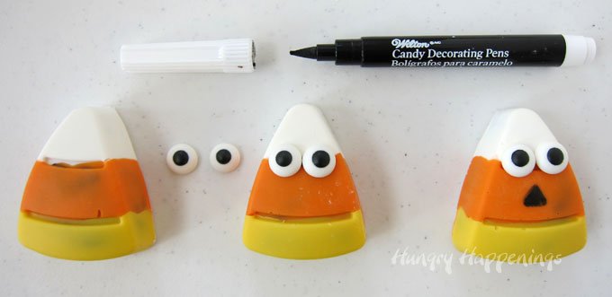 adding candy eyes and a nose and smile to the candy corn truffles. 