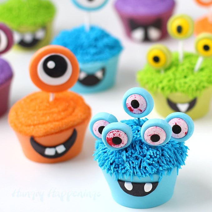 Serve these 100% edible Halloween cupcakes at your party this year and you wont have to deal with messy paper wrappers. These Cute Monster Cupcakes are made using edible cupcake wrappers created out of brightly colored modeling chocolate. Tutorial at HungryHappenings.com.