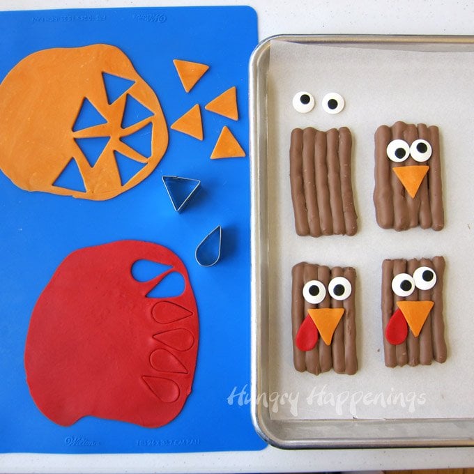 cutting out orange modeling chocolate beaks and red wattles to attach to the chocolate turkey pretzels with jumbo candy eyes. 