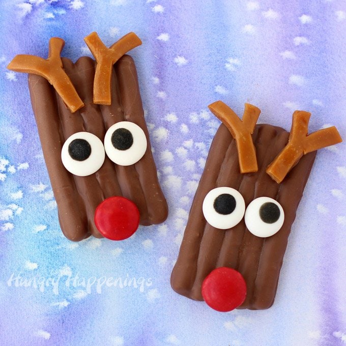 chocolate-dipped pretzel reindeer with red candy noses, candy eyes, and caramel antlers.