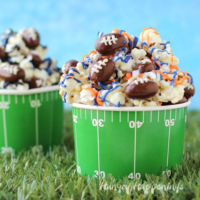 Snack on some Super Bowl Popcorn with Chocolate Almond Footballs while cheering on your favorite team. Make and decorate your white chocolate popcorn with white drizzles of orange and blue if you are cheering for the Broncos or with black, blue, and silver if you want the Panthers to win.