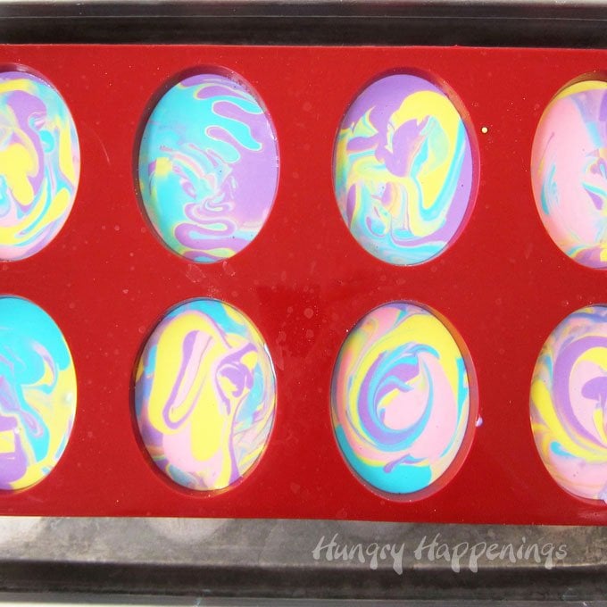 Colorful tie--dye swirled cheesecake Easter eggs. 