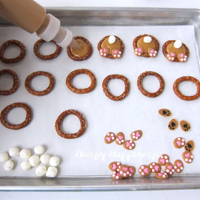 Pour peanut butter candy melts into pretzel rings then add a marshmallow tail and bunny feet to make cute Bunny Butt Pretzels. 
