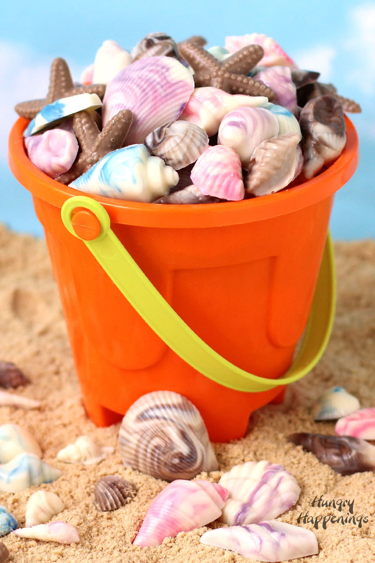 orange beach bucket filled with pretty swirled chocolate shells. 