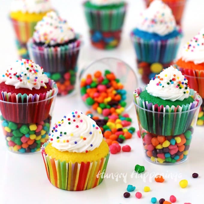 Colorful sprinkle coated Mini Cupcakes in Candy Filled Shot Glasses are the perfect size treats to serve at a kid's party. Each of these small cups is filled with tiny candies and topped with a brightly colored mini cupcake. 