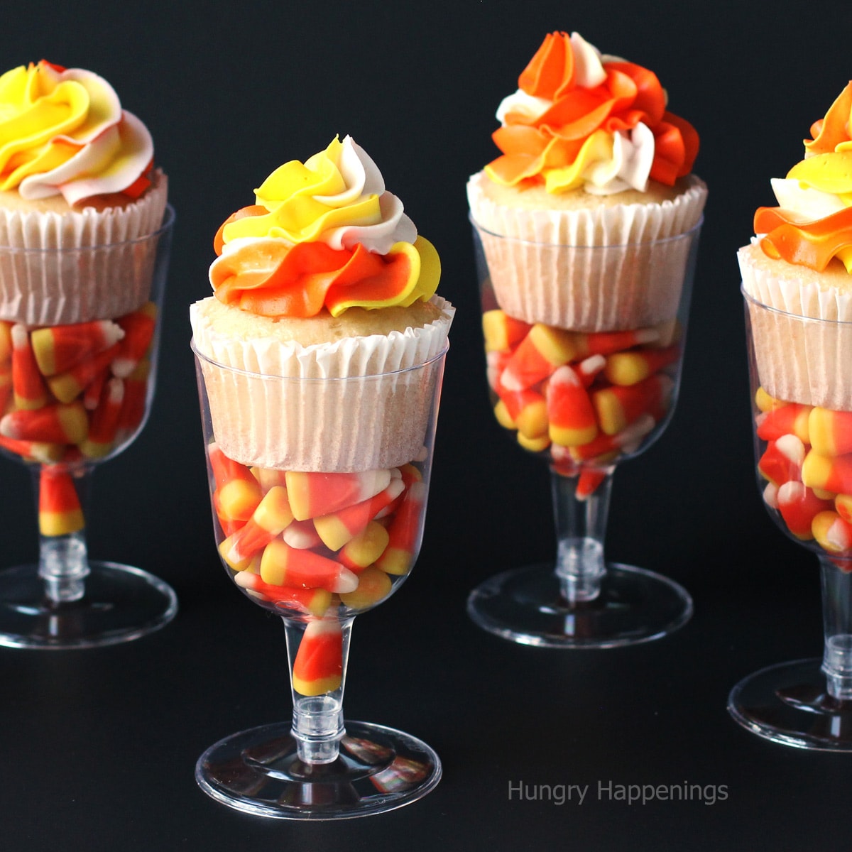 candy corn cupcakes in wine glasses filled with candy corn.