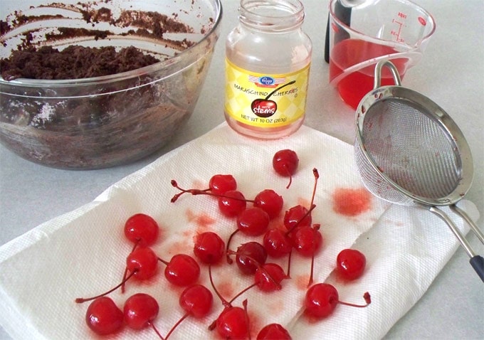 Drain maraschino cherries with stems on several rolls of paper towels then pat dry.