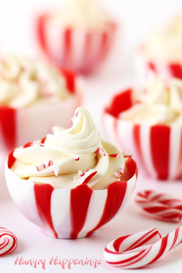 White chocolate cups with red stripes are filled with peppermint mousse and bits of candy canes.