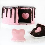 Cut into this pretty pink cake to reveal a strawberry cheesecake heart hiding inside a rich and decadent chocolate cake. This Strawberry Cheesecake Heart Surprise Cake will make Valentine's Day even more special.