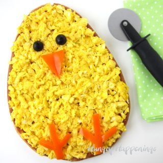 Make your Easter brunch egg-stra special by serving this adorable Breakfast Pizza Chick topped with ham, cheese, and scrambled eggs. See how easy it is to decorate using orange peppers and black olives.