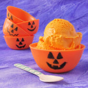 pumpkin bowls made with orange candy melts with one filled with orange ice cream.