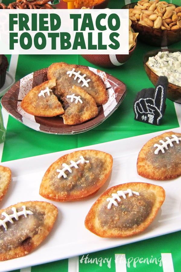 Super Bowl party display featuring Fried Taco Footballs and other fun game day snacks set out on a football field tablecloth. 