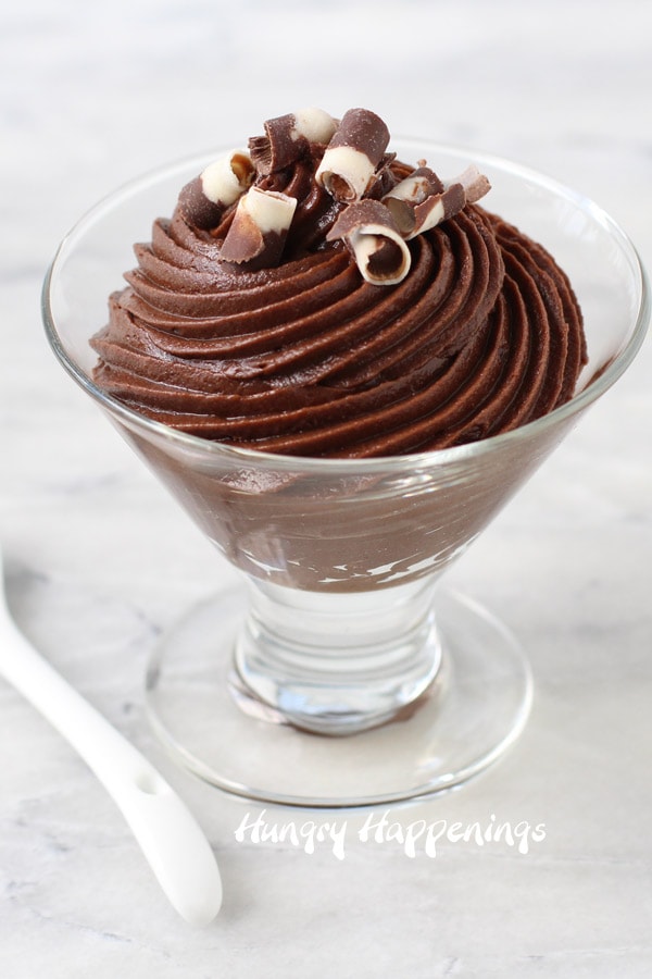 a single bowl filled with chocolate mousse topped with dark and white chocolate curls