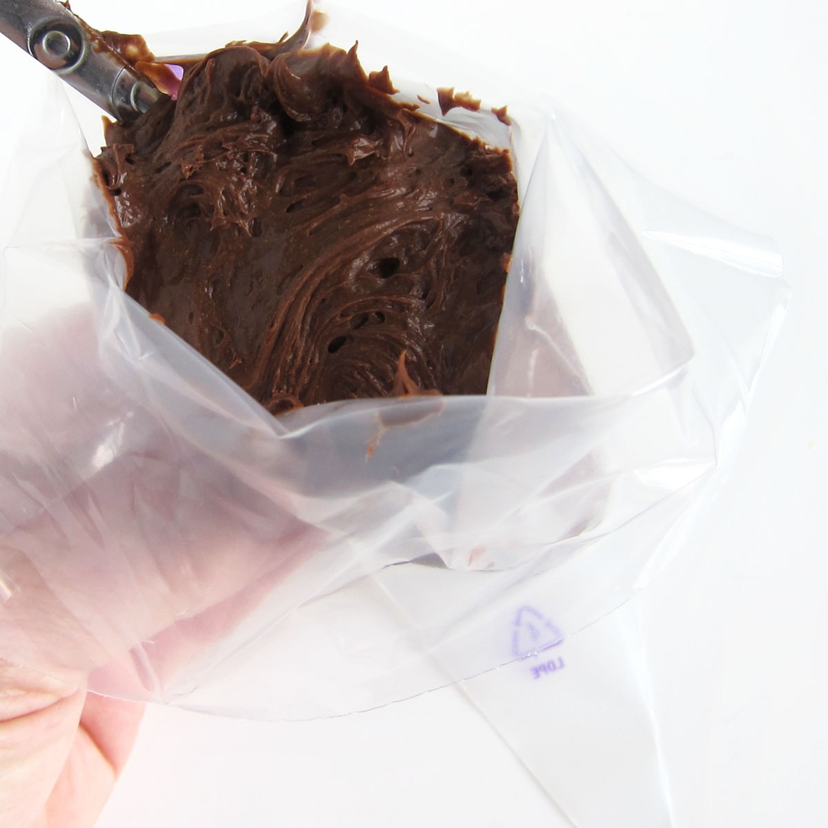 filling a disposable pastry bag with dark chocolate mousse