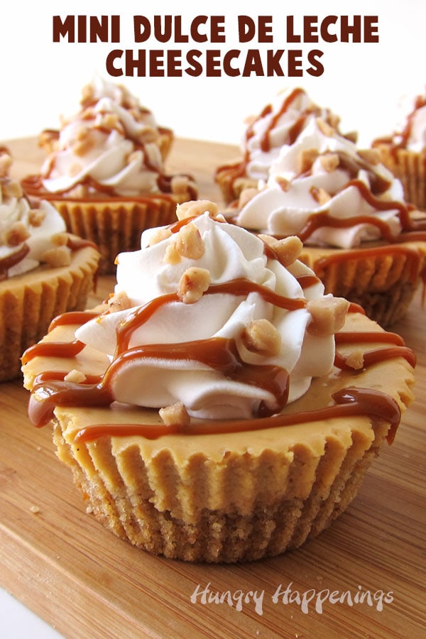 Mini Caramel Cheesecakes made using dulce de leche and topped with whipped cream, caramel sauce, and toffee bits.