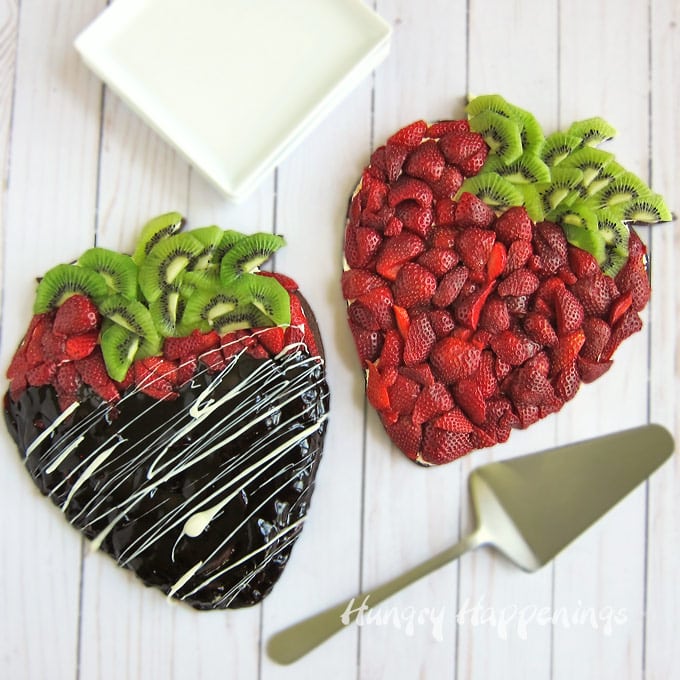 Fruit Pizza Strawberry - chocolate cookies cut into strawberry shapes topped with cream cheese frosting and fresh strawberries and kiwi. One is coated in dark chocolate ganache and drizzled with white chocolate.