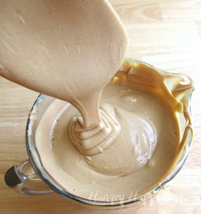 Creamy peanut butter fudge filling cascading down into a bowl.
