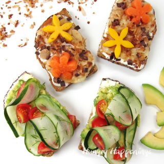 Avocado toast with cucumbers, tomatoes, and dill accompanied by Tropical Toast topped with bananas, toasted coconut, chocolate, almonds, mango and papaya flowers.