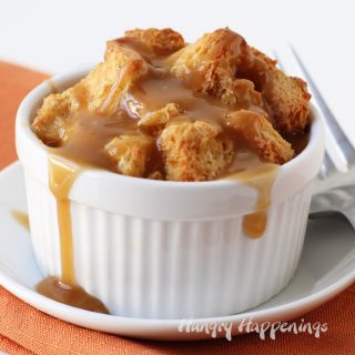 chai tea infused bread pudding topped with chai tea caramel sauce served in a small white ramekin set on a white saucer on an orange napkin