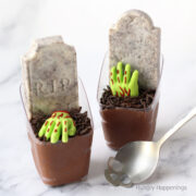 Chocolate Mousse graveyard cups with candy zombie hands and Cookies and Cream Tombstones.
