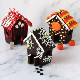 haunted cookie houses made using chocolate cookie dough decorated with bloody bones and skulls, or spider webs and spiders, or candy corn and orange, yellow, and white polka dots