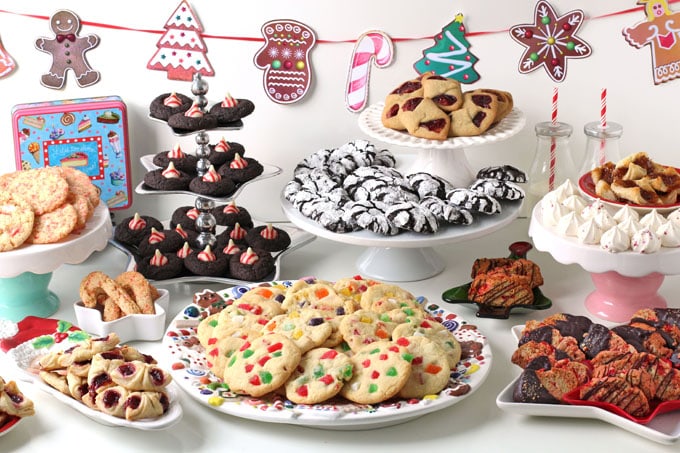 table filled with platters and cake stands filled with Christmas cookies for a cookie exchange